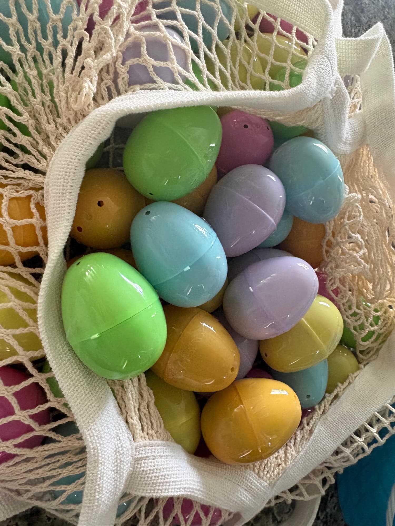 A mesh bag full of pastel plastic Easter eggs